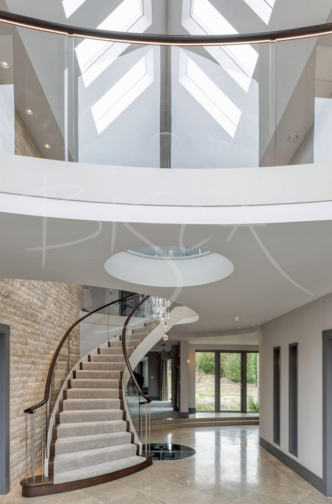 view from the bottom of the staircase including the balcony to the master bedroom