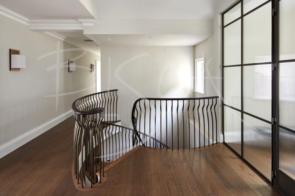 Hand-forged bronze balustrades create an elegant oak staircase Hand-forged bronze balustrades create an elegant oak staircase